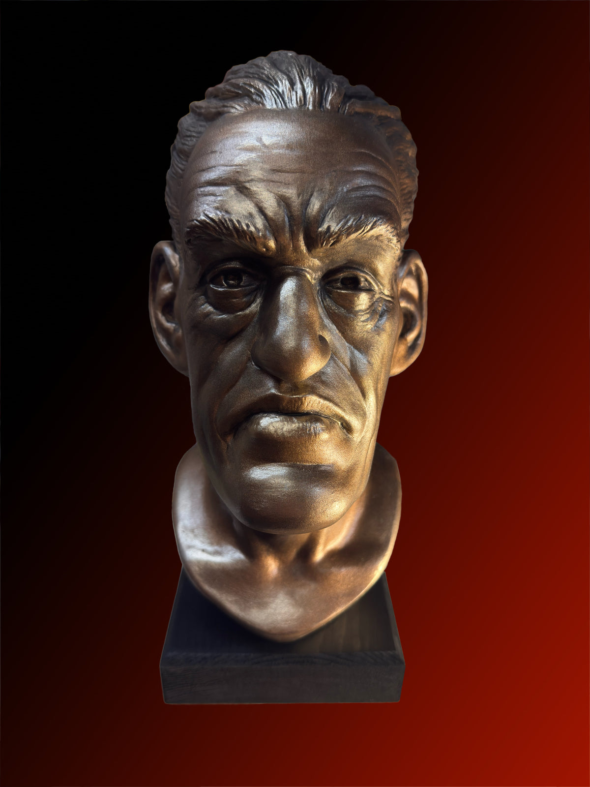 A realistic bronze bust sculpture of a man's face on a dark rectangular base, shown against a red-to-black gradient background.